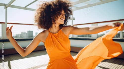 Portrait of a carefree young woman dancing in orange dress