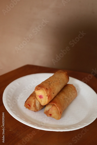 Lumpia or lunpia, traditional snacks from Indonesia. Traditional spring rolls contain stir-fried bamboo shoots, eggs, and chicken or shrimp photo