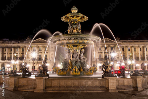 Fountain of the Seas located in Place de la Concorde in central Paris, France, at night - Motion blur achieved with long exposure on a fountain with many golden statues of Greek gods photo