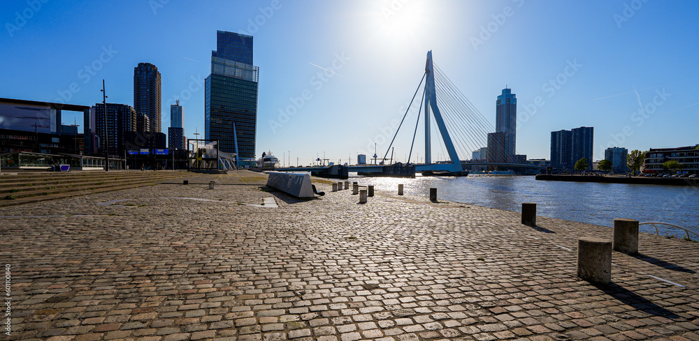 View of the Erasmus suspension bridge in Rotterdam from the cobbled waterfront promenade by the river Meuse in the Netherlands