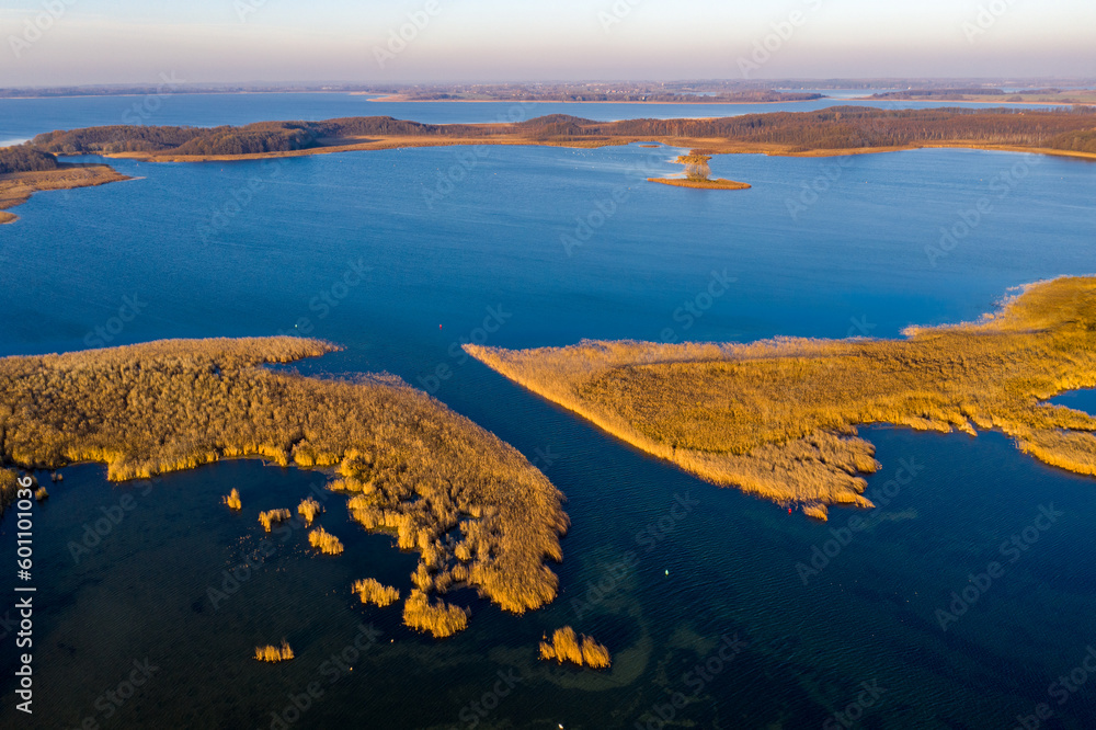 Fototapeta premium Masurian Lake District in Poland - beautifiul drone landscape, blue water, forest, autumn sunset time, Mazury great lakes