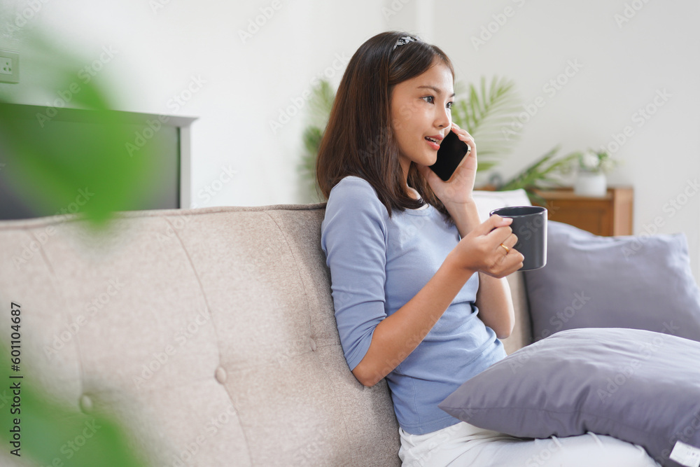 Work from home concept, Business women talk on phone with colleague while working on couch at home Work from home concept, Business women talk on phone with colleague while working on couch at home