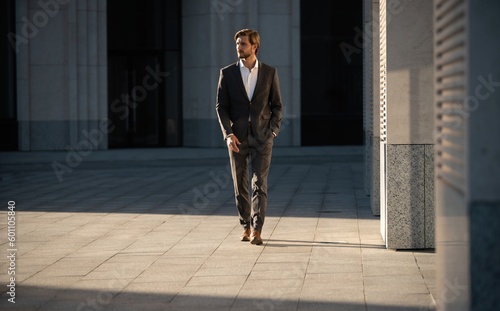 Obraz na płótnie Elegant handsome man in classic suit standing near the office building