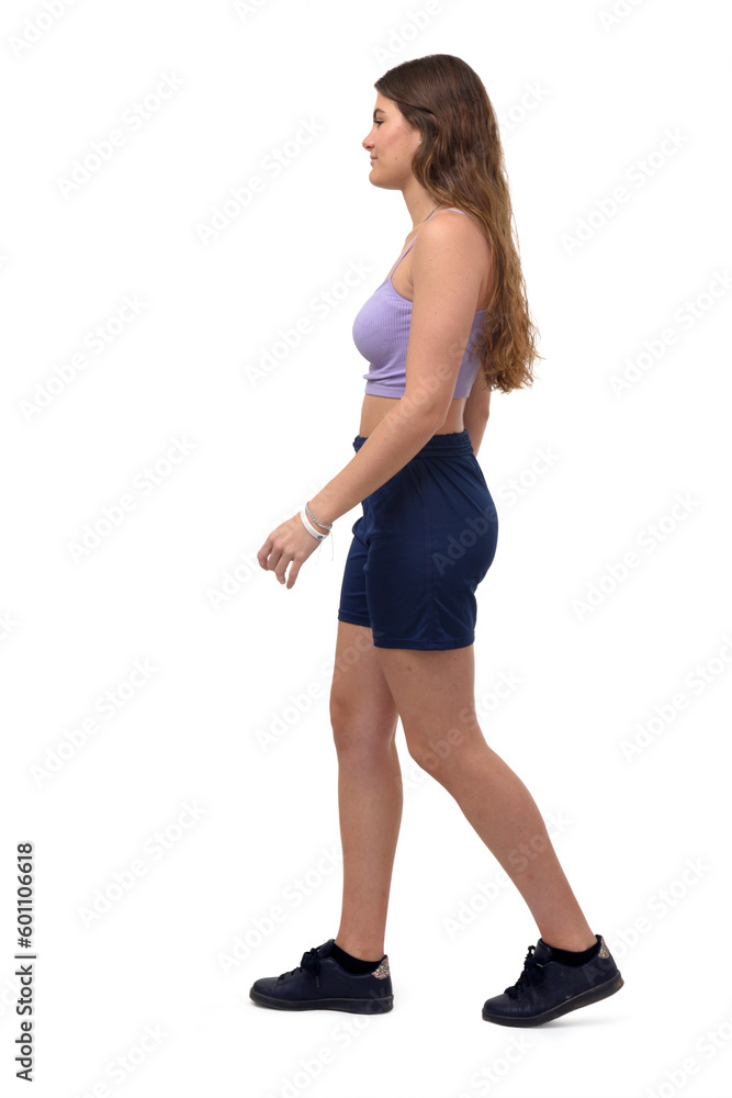 Fototapeta premium side view of a young girl walking on white background