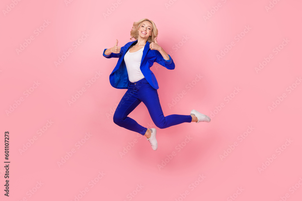 Full length photo of nice excited person jumping arms fingers demonstrate thumb up isolated on pink color background