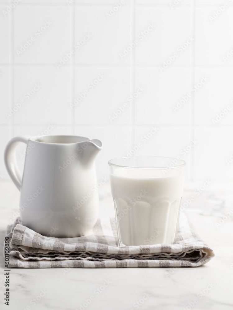 Glass of milk on a light background. Stylish kitchen background.