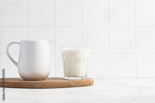 Glass of milk on a light background. Stylish kitchen background.