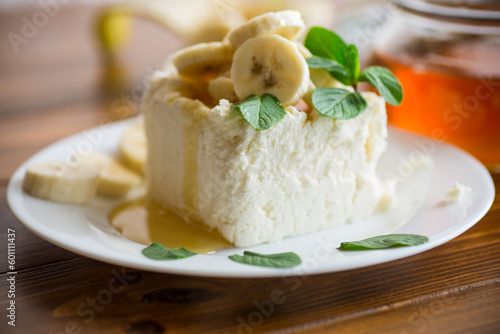 Portion of homemade milk curd with banana slices and honey