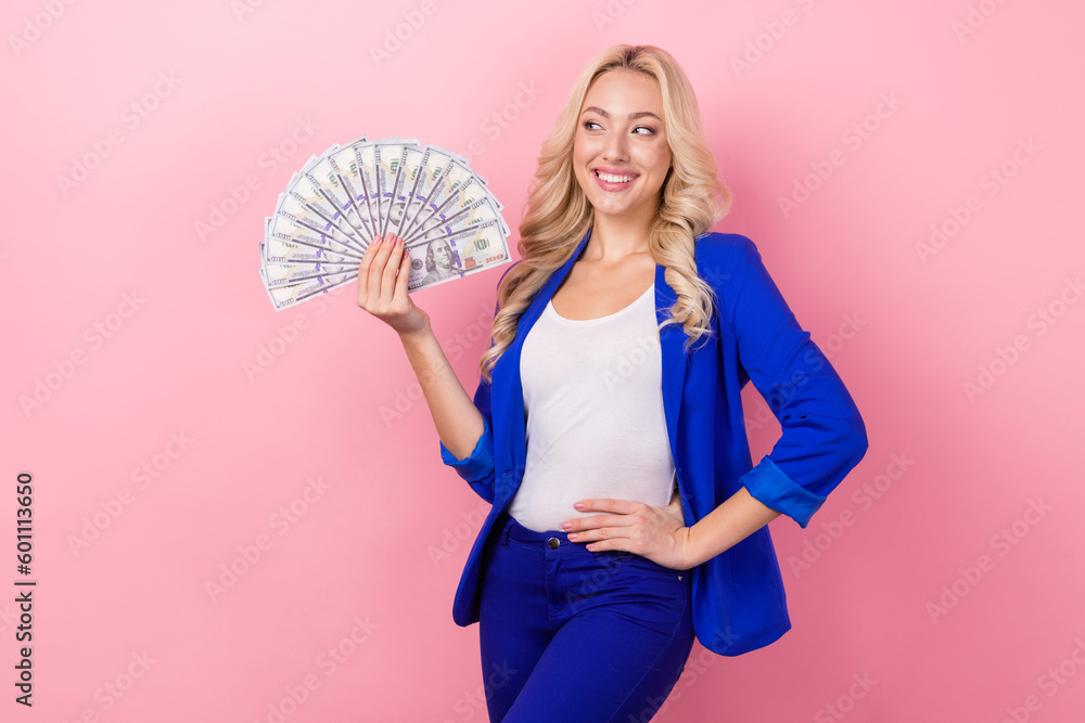 Photo of lovely cheerful person put hand waist hold dollar bills look empty space isolated on pink color background Photo of lovely cheerful person put hand waist hold dollar bills look empty space isolated on pink color background