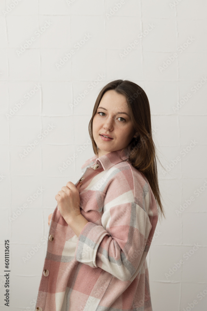Young beautiful woman in plaid shirt posing and looking at the camera Young beautiful woman in plaid shirt posing and looking at the camera