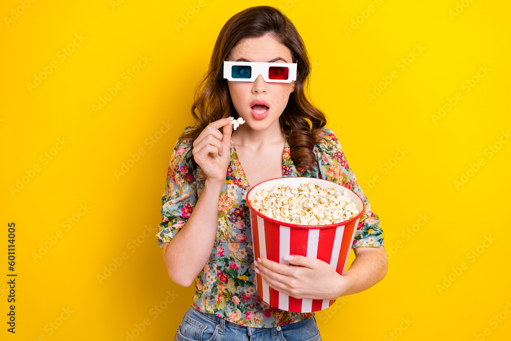 Portrait of impressed girl hand hold pop corn bucket open mouth watch movie 3d glasses isolated on yellow color background