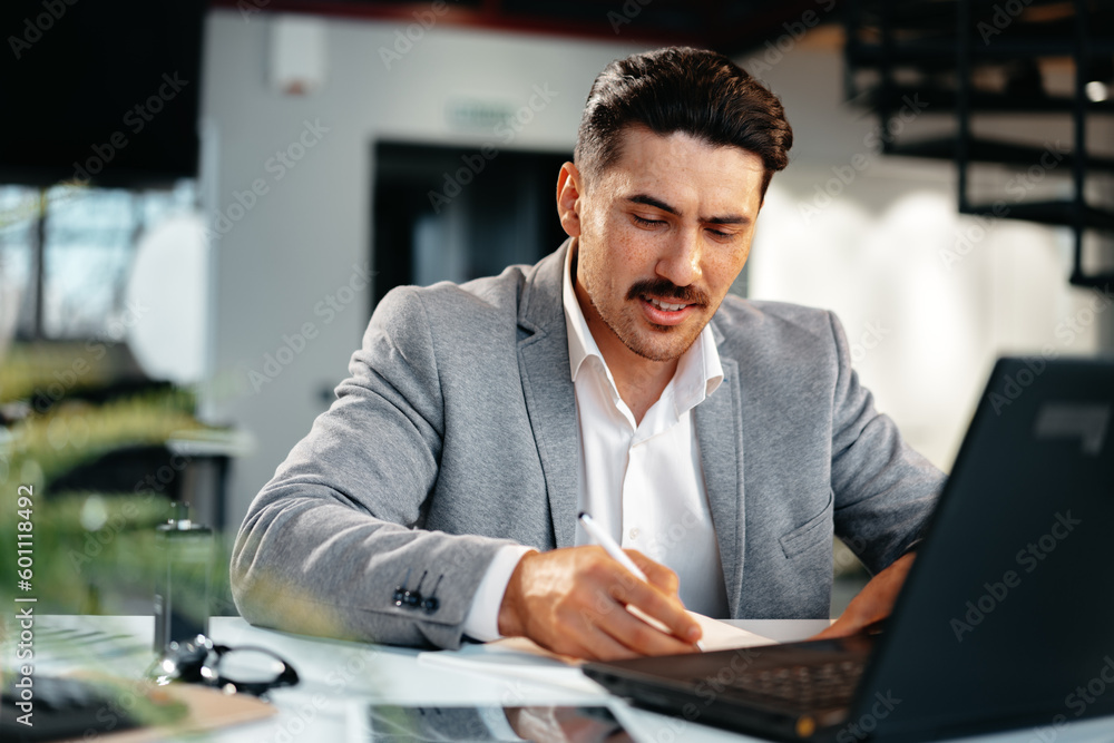 Obraz premium Young arab businessman working at the table in modern office