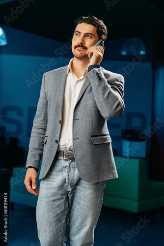 Young arab businessman working at modern office, talking on mobile phone