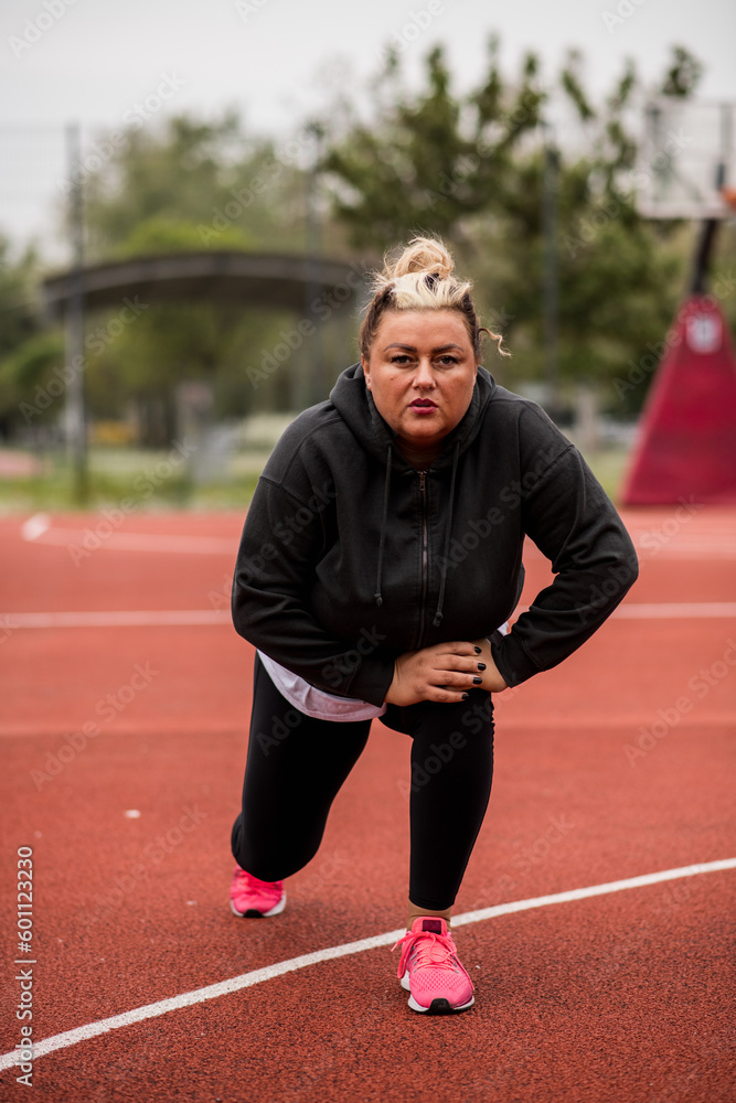 Fototapeta premium Fat Hispanic woman stretching for a workout outside