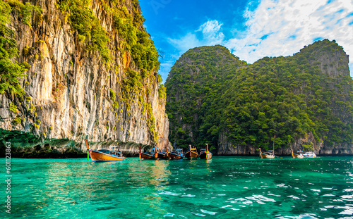 View of long tail boats on turquoise water at ocean near Ko Phi Phi islands, Thailand. Concept of exotic vacation in tropical paradise. Limestone rock in background. © Martin