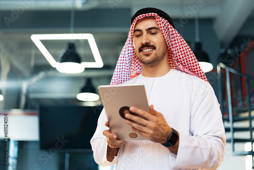 Arab muslim businessman using digital tablet in modern office photo