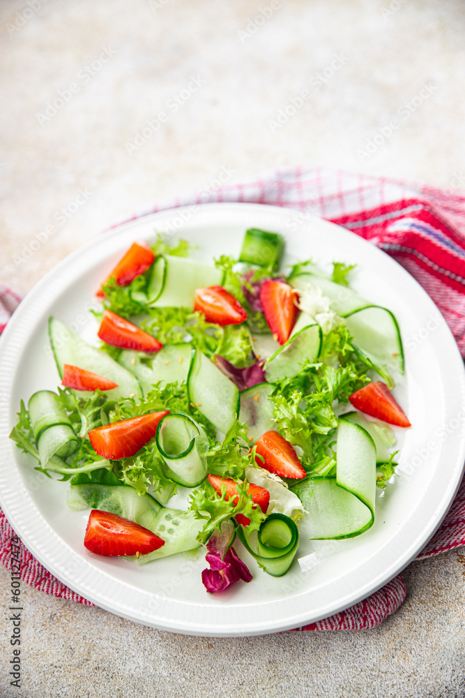 salad cucumber, strawberry, lettuce healthy meal food snack on the table copy space food background rustic top view keto or paleo diet veggie vegan or vegetarian food salad cucumber, strawberry, lettuce healthy meal food snack on the table copy space food background rustic top view keto or paleo diet veggie vegan or vegetarian food