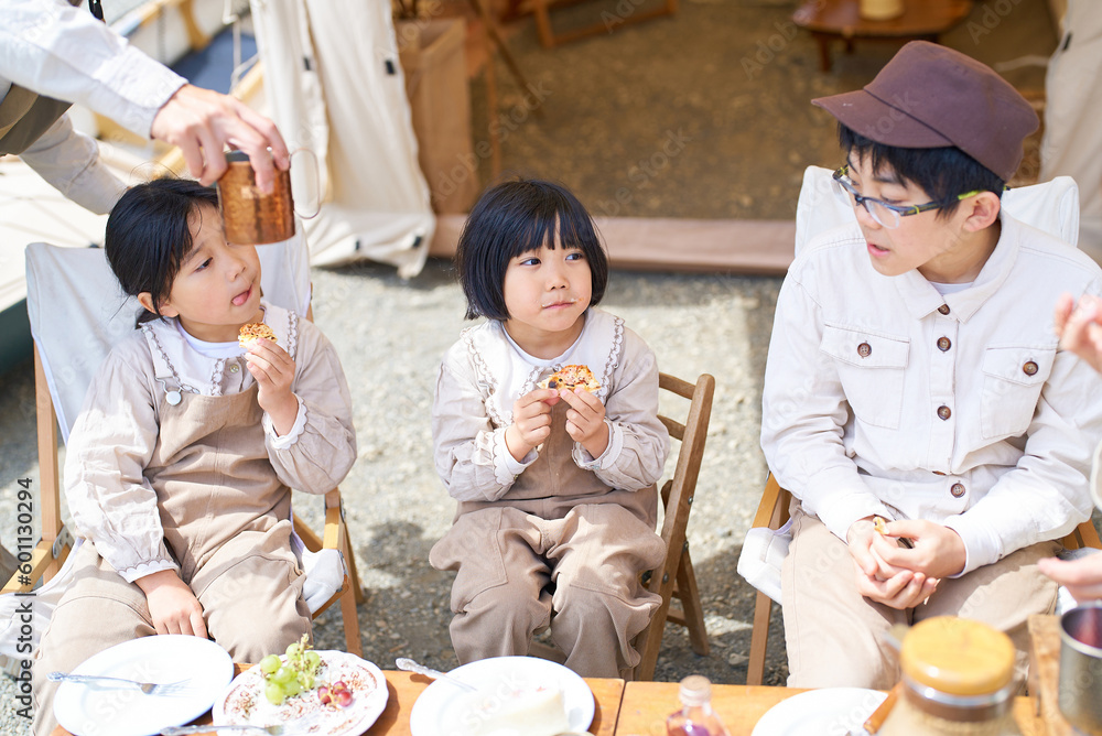 キャンプで食事を楽しむ子供たちと親 キャンプで食事を楽しむ子供たちと親