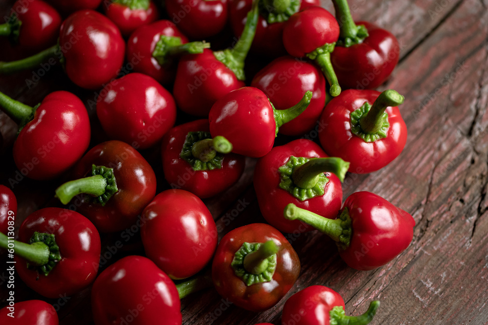 Red hot Cherry pepper. Lot of ripe peppers on wooden surface. Pepper harvest. Bright spices. Spicy food. North American pepper. Wooden background. Close-up. Soft focus. Top view. Red hot Cherry pepper. Lot of ripe peppers on wooden surface. Pepper harvest. Bright spices. Spicy food. North American pepper. Wooden background. Close-up. Soft focus. Top view.