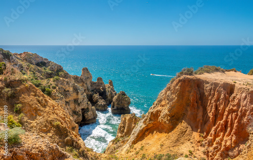 Ponta da Piedade (point of mercy) a headland with dramatic yellow-golden cliff-like rock formations, arches and grottos along the coastline of the town of Lagos, Algarve, Portugal © Luis
