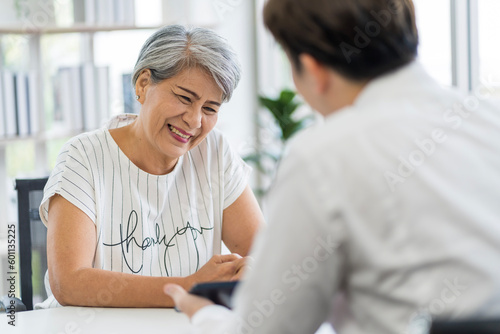 Asian seniors who are healthy, in a good mood, smiling, talking with financial or life insurance staff to take care of life after retirement...