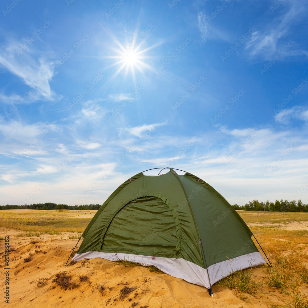 small green touristic tent among sandy prairie, summer travel background