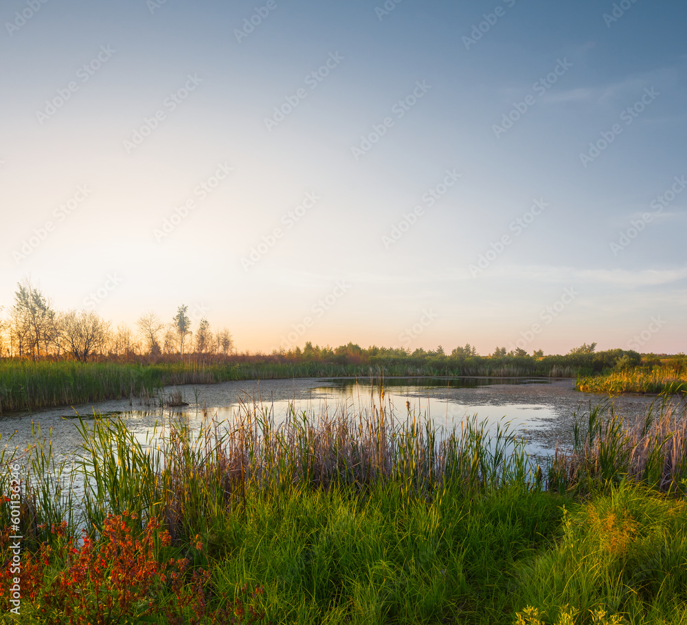 small calm lake in prairie at the sunset