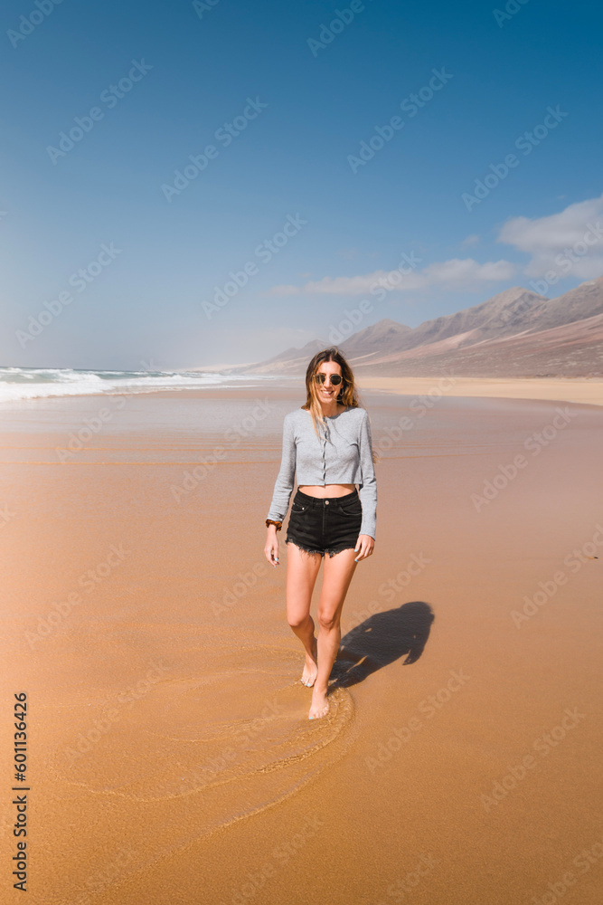 happy young woman on the wild beach of cofete during her summer trip on the canary island of fuerteventura happy young woman on the wild beach of cofete during her summer trip on the canary island of fuerteventura
