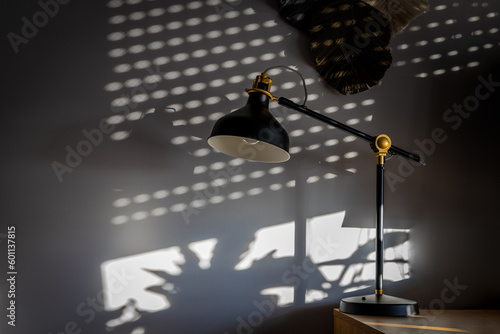 a black loft lamp placed on a table with surface to put on banner that reads  free space  in the background. This image is ideal for illustrating the concept of minimalism  modern design  and creating