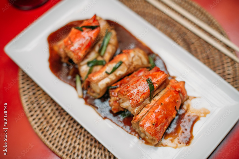 A ready-made dish of fresh red Kamchatka crab legs on the table in the restaurant hall. Cooked crab meat in a shell on a plate A ready-made dish of fresh red Kamchatka crab legs on the table in the restaurant hall. Cooked crab meat in a shell on a plate