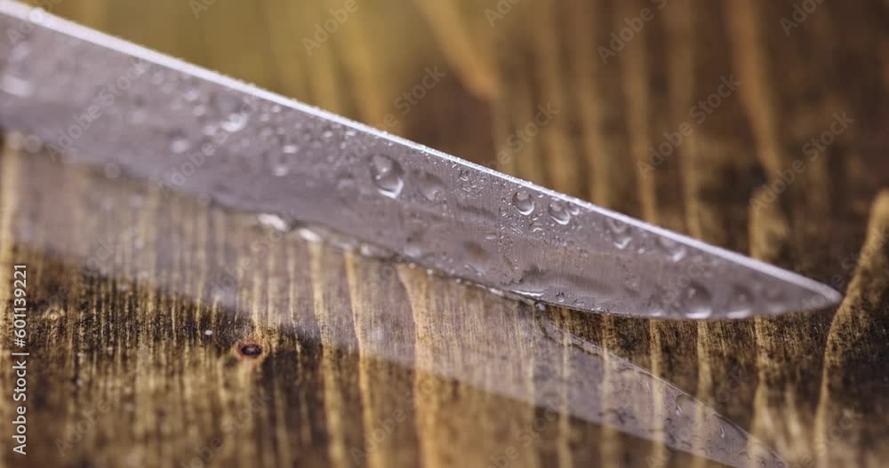 a sharp little knife covered with water drops, a small knife in water drops on a wooden table a sharp little knife covered with water drops, a small knife in water drops on a wooden table