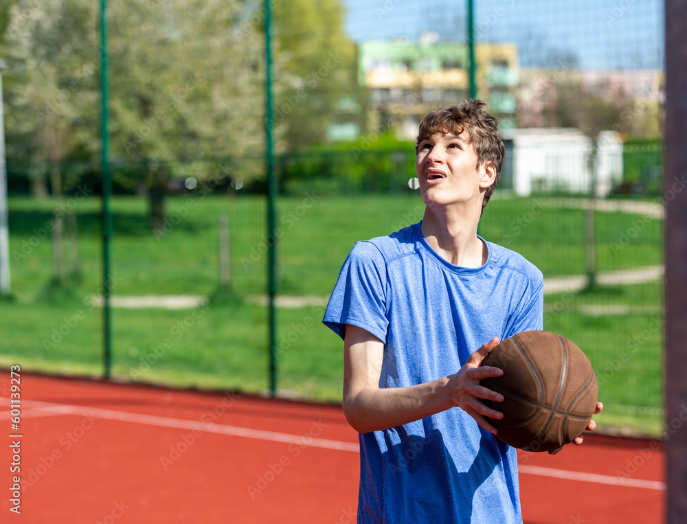 Boy playing basketball on court. Teenager running in the stadium. Sports, hobby, active lifestyle for boys Boy playing basketball on court. Teenager running in the stadium. Sports, hobby, active lifestyle for boys