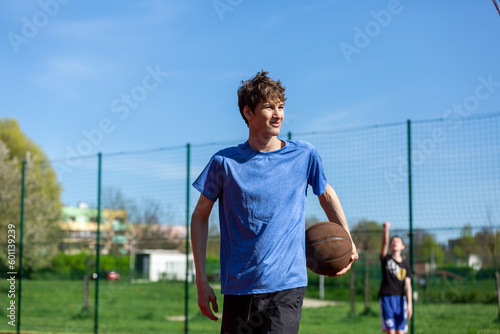 Boy playing basketball on court.Teenager running in the stadium. Sports, hobby, active lifestyle for boys 