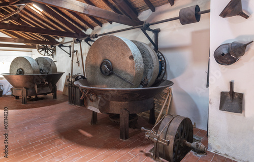 Billede på lærred Olive oil press is installed in premises of ancient equipment for production of olive oil, stone mill and mechanical press, olive oil mill