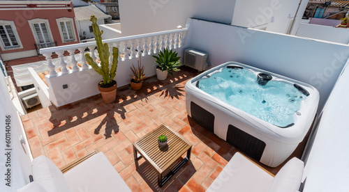 On the terrace of the house there is a modern outdoor Jacuzzi tub for tourists to relax. pots with plants and views of the houses.