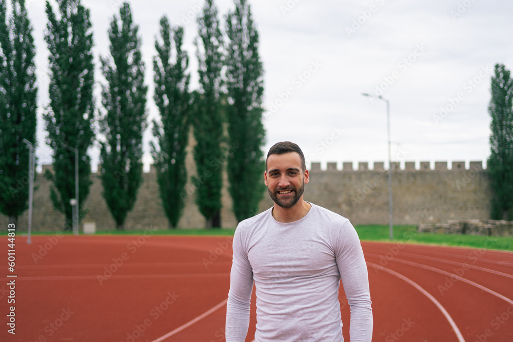 Portrait of young man athlete on running stadium track

