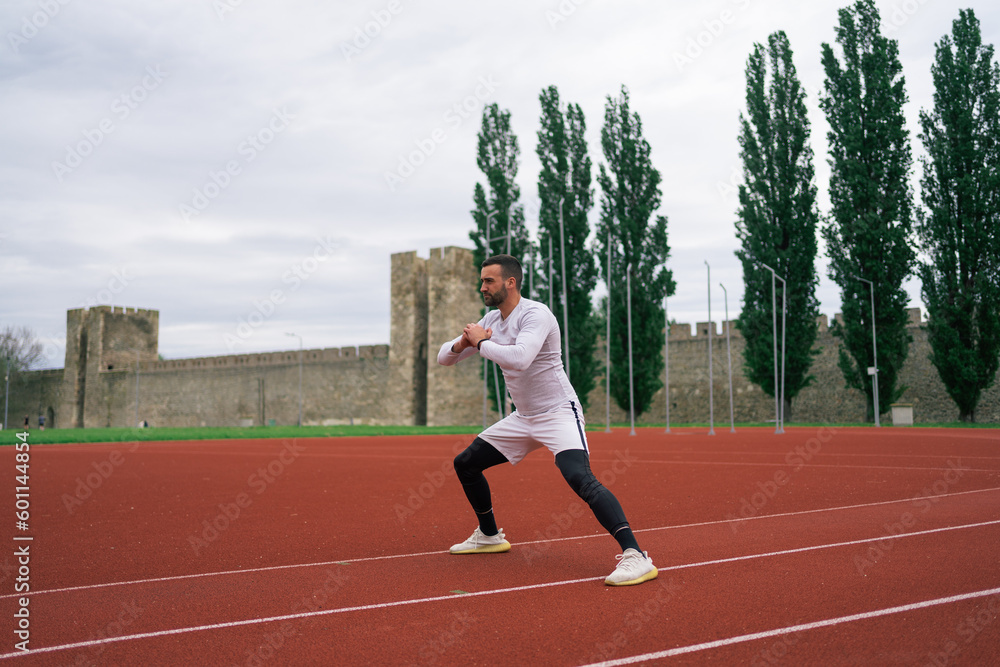 Fototapeta premium Man Warming Up and Stretching Before Workout and Running