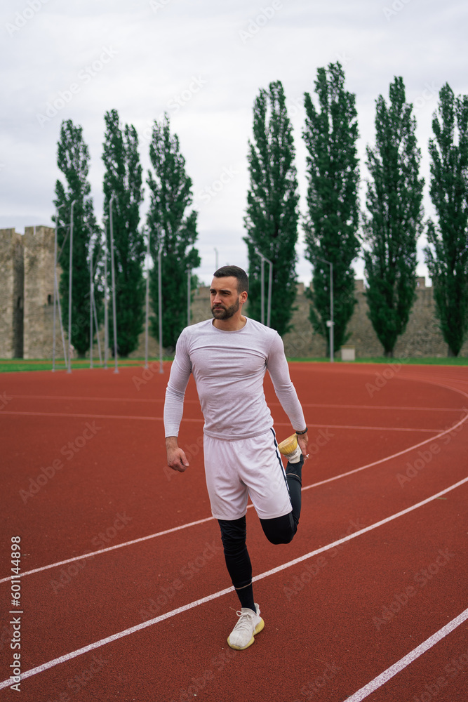 Obraz premium Man Warming Up and Stretching Before Workout and Running