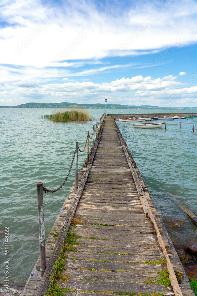wooden pier in Balatonlelle with colorful boats on lake Balaton blue sky and water wooden pier in Balatonlelle with colorful boats on lake Balaton blue sky and water