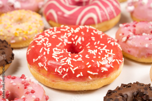 Donuts with red and pink glaze, top view. Lots of donuts, sweet and delicious food