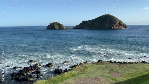 The calm ocean and waves in front of Ilheu de Vila Franca in Sao Miguel in a sunny day, Azores Islands, Portugal photo