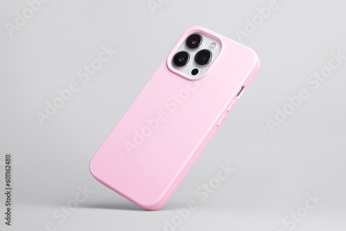 iPhone 13 Pro in pink soft silicone case falls down back view, phone case mockup isolated on grey background