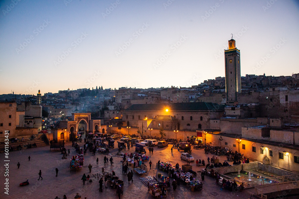 Arabic square Rcif in Fes in Morocco at sunset. People in market and street food.  