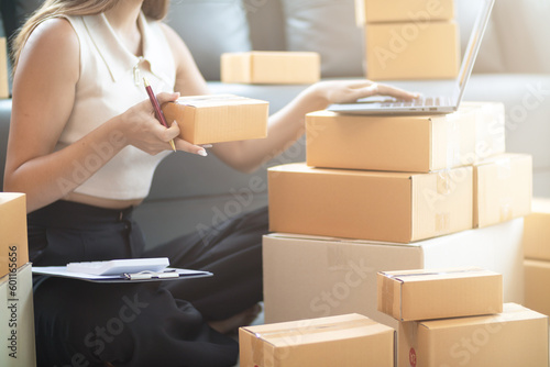 small sme entrepreneur is packing products into parcel boxes in preparation for transporting them to freight forwarder to deliver to customers with incoming orders. Concept Ecommerce Team online sales