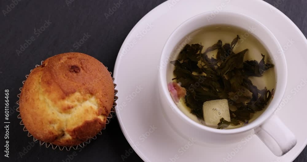 Brewed strong green tea in a white porcelain cup, a close-up of high-quality leafy green tea Brewed strong green tea in a white porcelain cup, a close-up of high-quality leafy green tea
