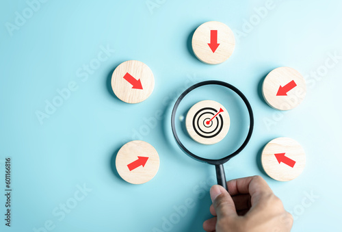 Magnifier glass focus to target icon with arrow to planning and management business development leadership and customer target group.