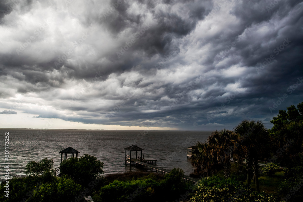 Storm clouds moving in over water and pier
