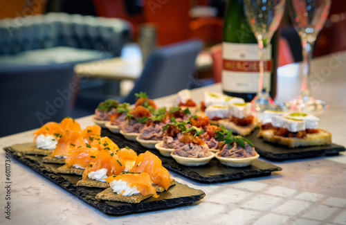 Variety of canapés including smoked salmon, cream cheese on a sesame cracker with champagne and glasses at a corporate function/event or wedding celebration/formal party