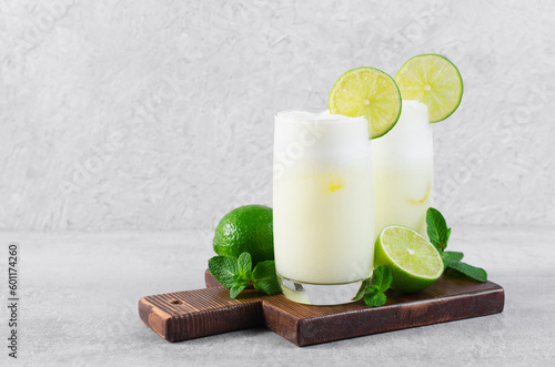 Brazilian Lemonade, Refreshing Creamy Lemonade or Limeade with Lime Slices and Mint on Grey Background