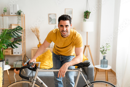 Smiling man with bicycle at home.